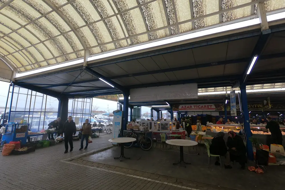 Gönen'in kapalı pazar yerinde tezgahlar ve alışveriş yapan yerel halk