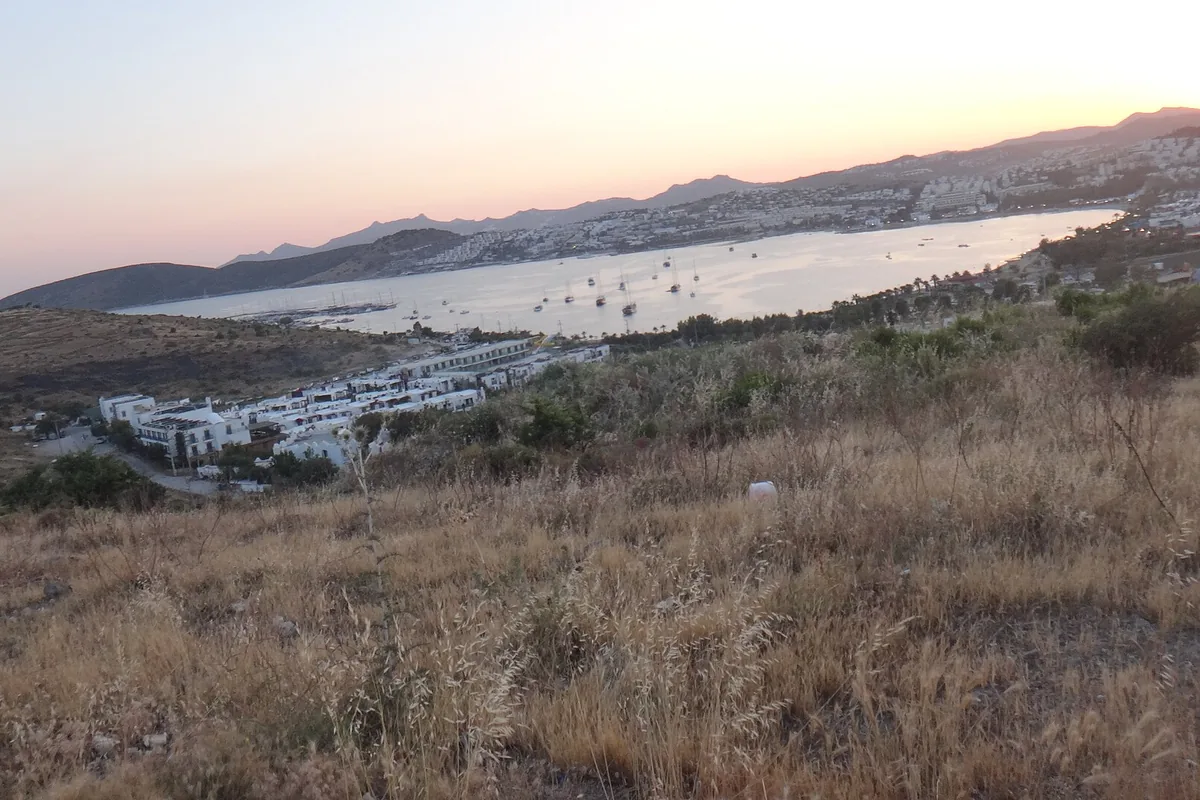 Gümbet ve Eskiçeşme sırtlarından bakışta yamaca yayılan tatil siteleri ve koy