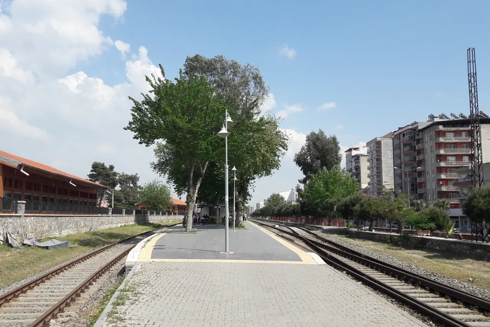 İncirliova tren istasyonu platformu, raylar ve arka planda ilçenin apartmanları