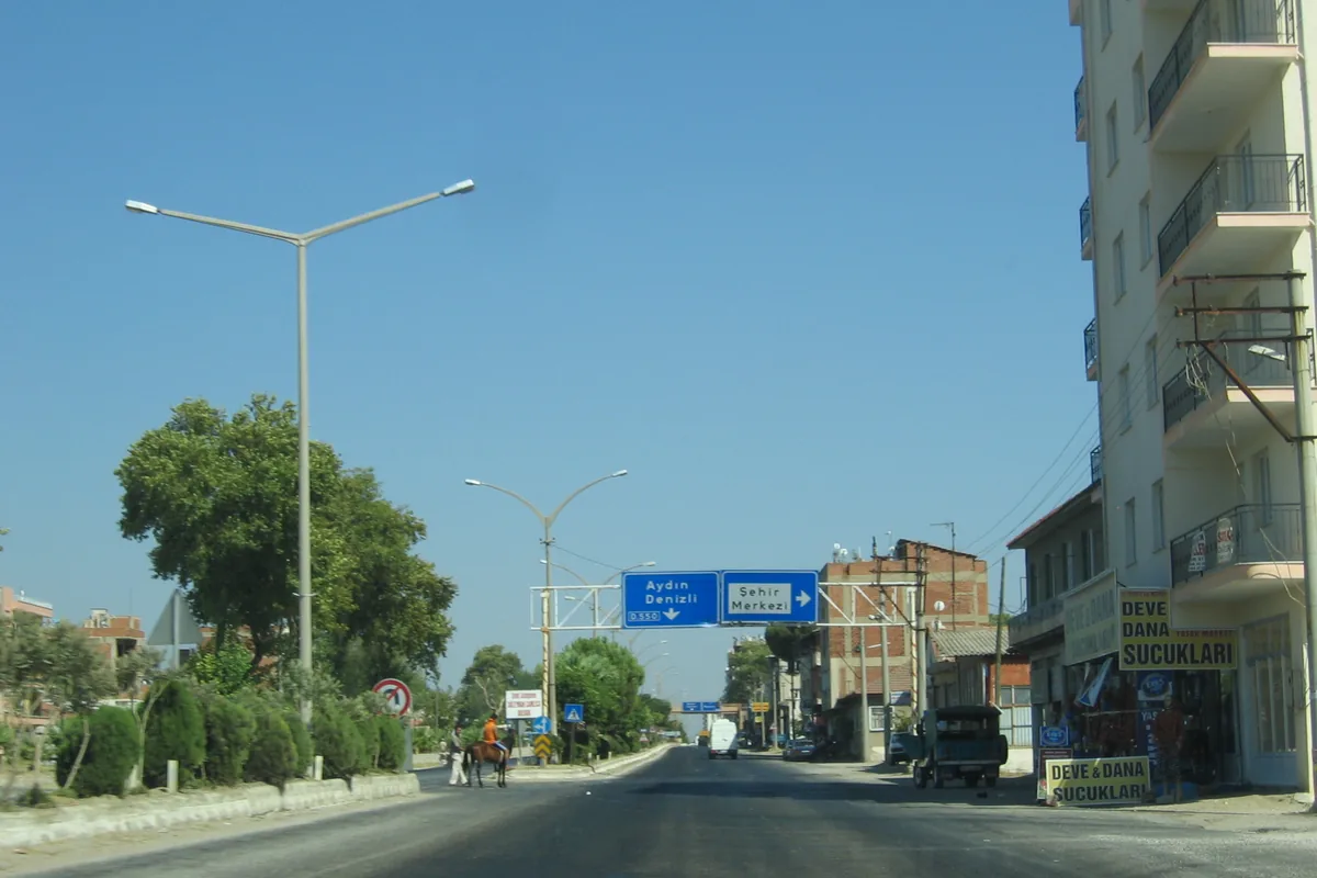 İncirliova ana caddesinde deve ve dana sucuğu satan dükkanlar ve yönlendirme tabelaları