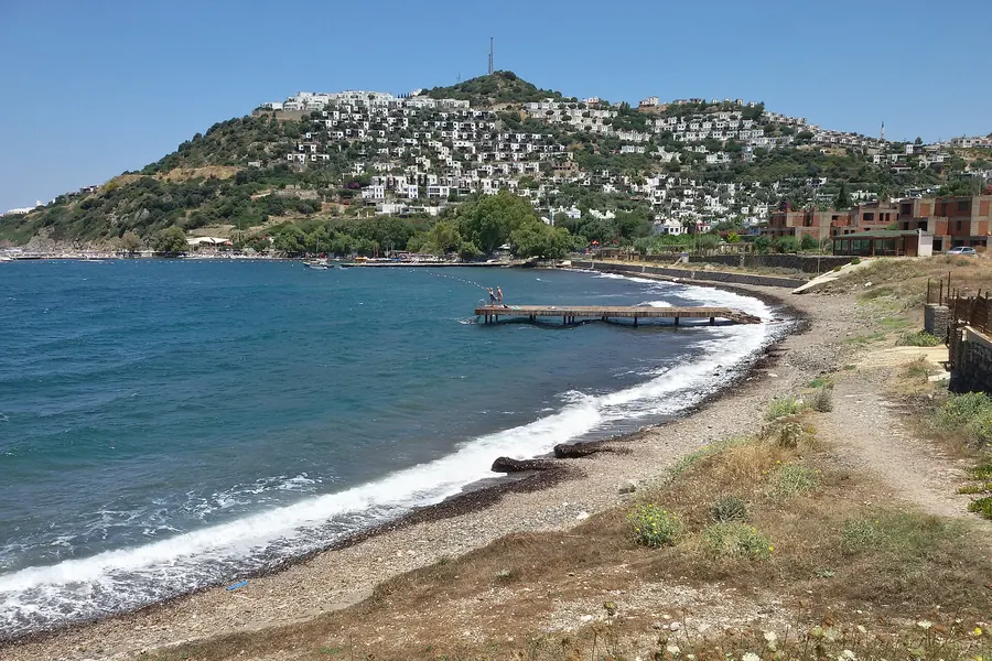 Koyunbaba'da gündüz koy, ahşap iskele ve yamaç villa yerleşimi