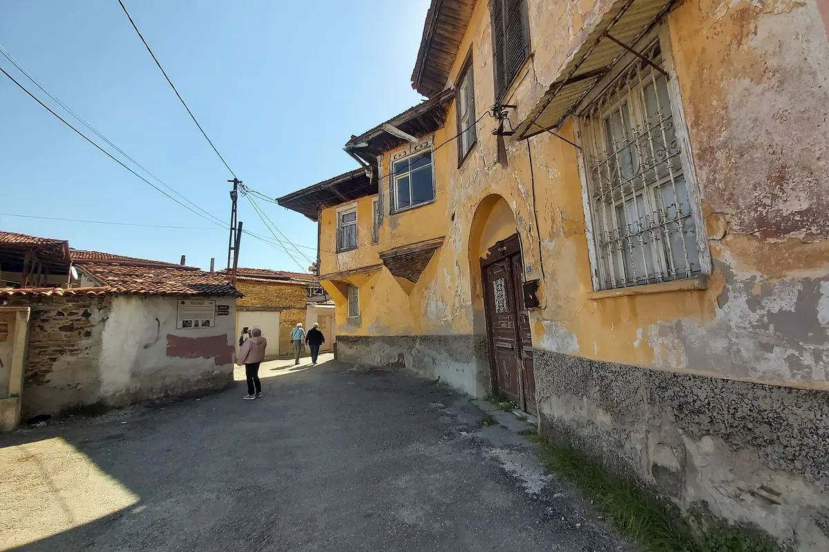 Kula'da dar bir sokakta tarihi evlerin sıralandığı bir mahalle görünümü
