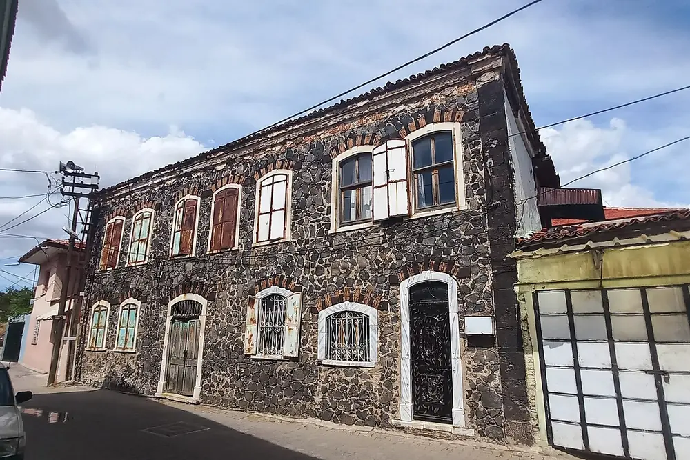 Kula'da taş ve tuğla işçiliğiyle örülmüş iki katlı tarihi evlerin sokak boyunca sıralanışı