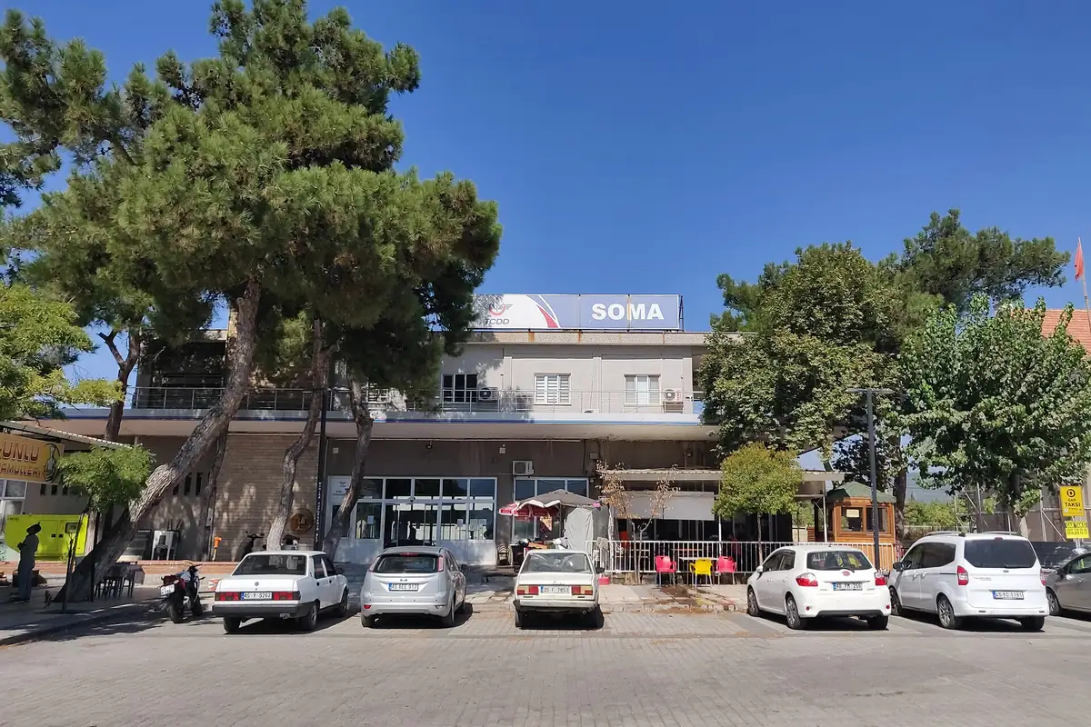 Soma TCDD Garı'nın ön cephesi, çatısındaki SOMA tabelası ve önündeki meydan